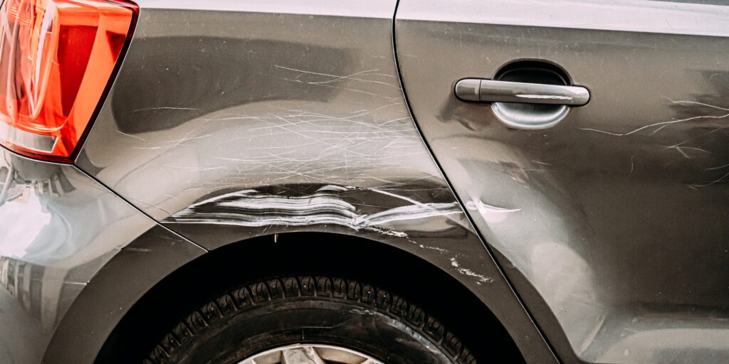Broken Scratched Bumper Luxury Car Scratched With Deep Damage To Paint. Abandoned Car After Accident